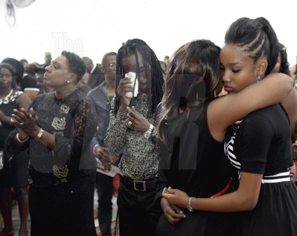 Gladstone Taylor/ Photographer
Daughter of the deceased, AzanNia Nesbeth (right), gets a comforting hug from her grandmother,  Donna Wedderburn-Allen, while Nesbeth dries his tears. Olivia Grange (left), minister of entertainment, sports, culture and gender affairs, looks on.
Mother Donna Wedderburn-Allen (second right) offers a comforting hug to AzanNia Nesbeth (daughter). husband Greg Nesbeth (second left) mourns and Olivia Grange (minister of entertainment, sports culture and gender affairs) look on.