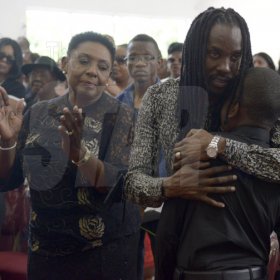 Gladstone Taylor/ Photographer

Greg Nesbeth (center) comforts his son Sakani Nesbeth (right), Oliva Grange (Minister of  Entertainment, Sports, Culture and Gender Affairs) look on.

funeral service for the life of Annmarie Elliott-Nesbeth held at the new life assembly of God in kingston on saturday march 12, 2016