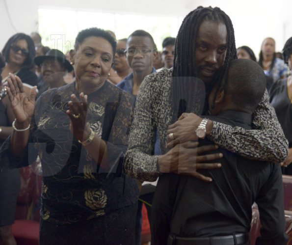Gladstone Taylor/ Photographer

Greg Nesbeth (center) comforts his son Sakani Nesbeth (right), Oliva Grange (Minister of  Entertainment, Sports, Culture and Gender Affairs) look on.

funeral service for the life of Annmarie Elliott-Nesbeth held at the new life assembly of God in kingston on saturday march 12, 2016