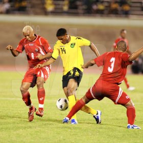 Ricardo Makyn/Staff Photographer.
Jamaica's Khari Stephenson attempts to dribble through the middle of two Pananian players in a friendly international at the National Stadium last night.  Jamaica won the game 3-2.
