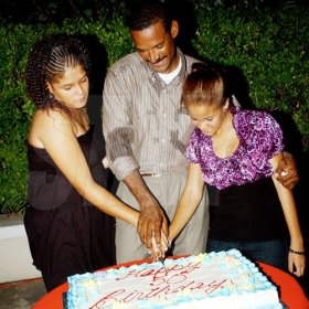 Winston Sill / Freelance Photographer
Capt. Errol Stewart celebrates  his 50th birthday with a grand swinging party, held at JDF Officers Club, Up Park Camp on Saturday night August 29, 2009. Here Capt. Stewart (centre) and his daughters-- Kayla Stewart (left); and Brianne Stewart (right) cuts the birthday cake.