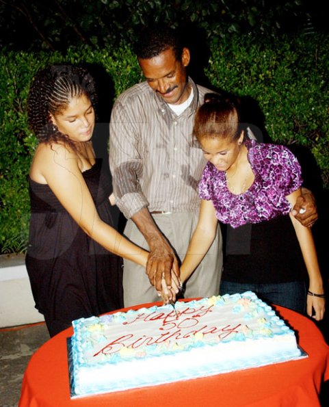 Winston Sill / Freelance Photographer
Capt. Errol Stewart celebrates  his 50th birthday with a grand swinging party, held at JDF Officers Club, Up Park Camp on Saturday night August 29, 2009. Here Capt. Stewart (centre) and his daughters-- Kayla Stewart (left); and Brianne Stewart (right) cuts the birthday cake.