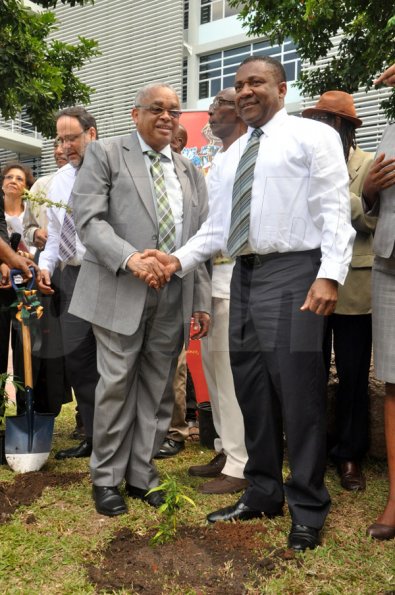 Jermaine Barnaby/Photographer
Professor Archibald McDonald (left) pro vice chancellor and principal UWI shake hands with Minister of Science, Technology, Energy and Mining, Phillip Paulwell at the launch for the symbolic planting of the first legal Marijuana Plant at the Lecture Theatre Two (2) , Faculty of Medical Sciences Teaching and Research Complex on Monday April 20, 2015.