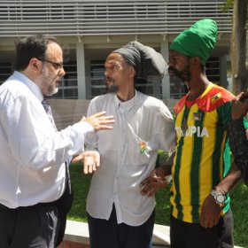 Jermaine Barnaby/Photographer
Minister of Justice Mark Golding (left) reasons with prophet Greg (second left), Ras Kahleh (second right) Ganja Growers and Producers Association and an unidentified man (right) at the launch for the symbolic planting of the first legal Marijuana Plant at the Lecture Theatre Two (2) , Faculty of Medical Sciences Teaching and Research Complex on Monday April 20, 2015.