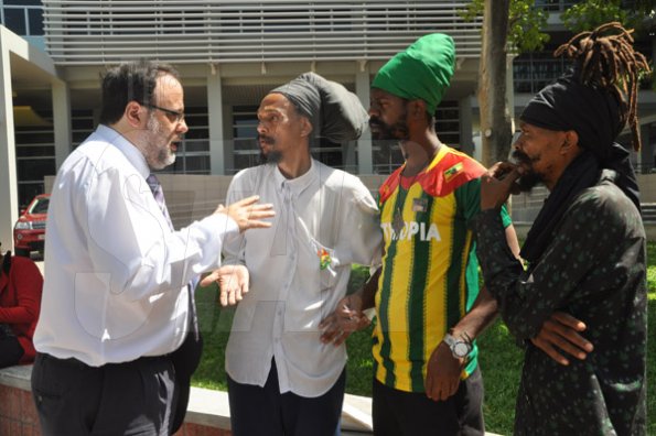 Jermaine Barnaby/Photographer
Minister of Justice Mark Golding (left) reasons with prophet Greg (second left), Ras Kahleh (second right) Ganja Growers and Producers Association and an unidentified man (right) at the launch for the symbolic planting of the first legal Marijuana Plant at the Lecture Theatre Two (2) , Faculty of Medical Sciences Teaching and Research Complex on Monday April 20, 2015.